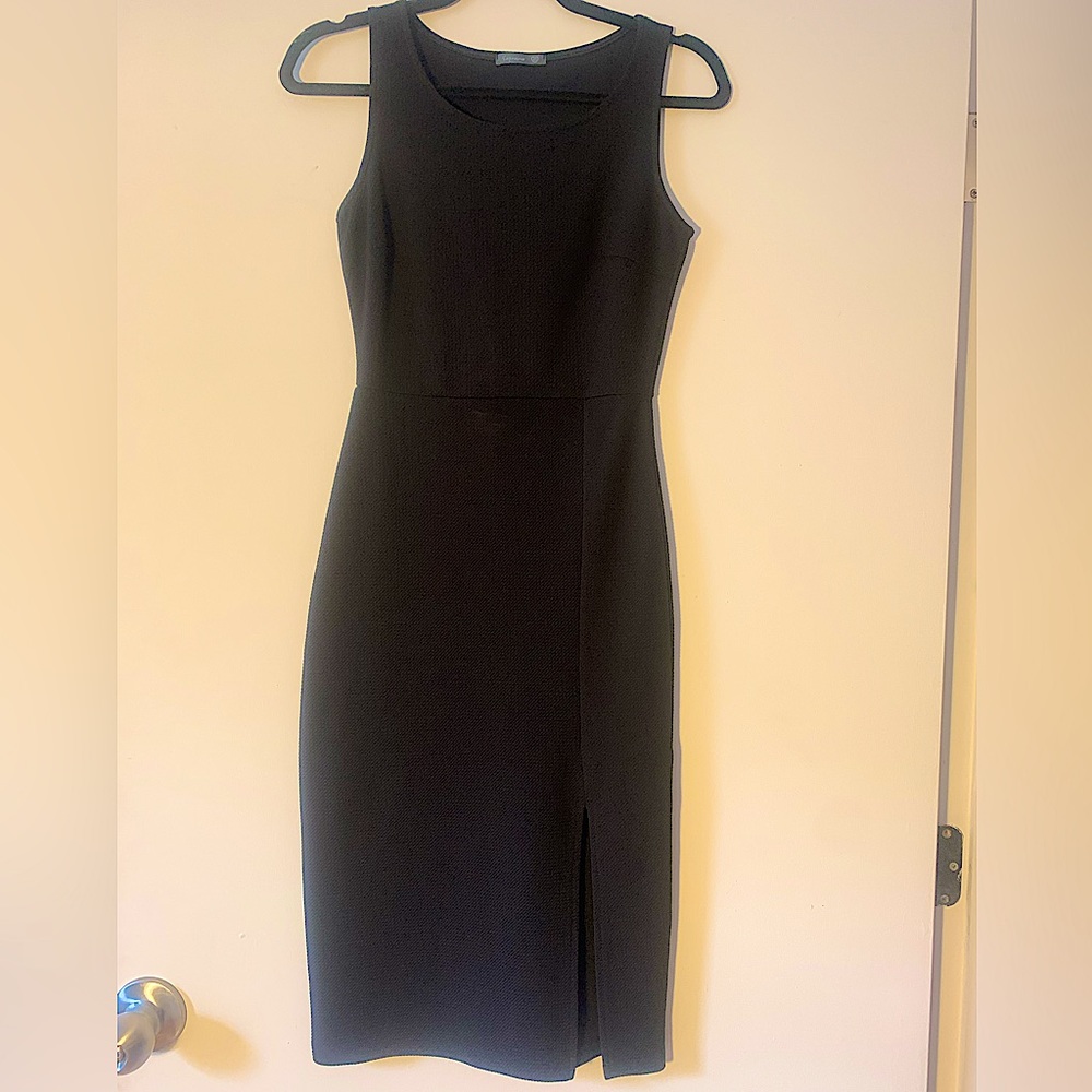Black bodycon knee - mid length dress with sexy slit. Form fitting.
